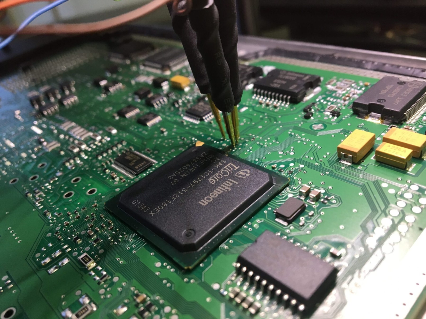 A probe on the chip of an engine control unit circuit board during ECU tuning at SBR